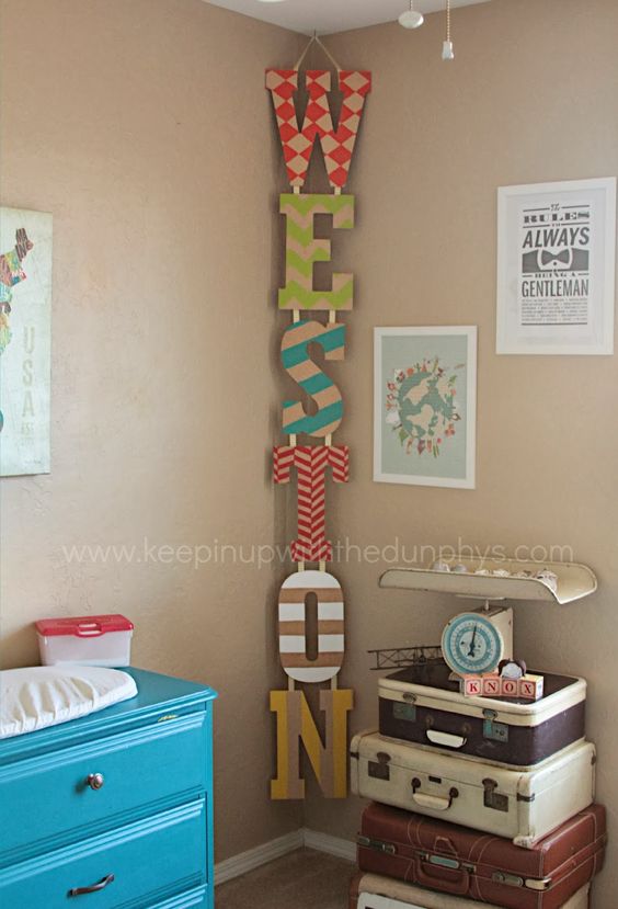 Painted Name Letters Hung Vertically In The Corner. 