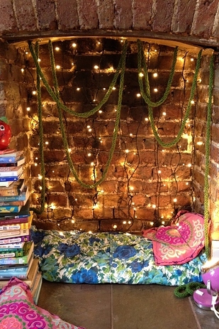 Turn a Fireplace Into a Nook With String Lights and Pillows. 